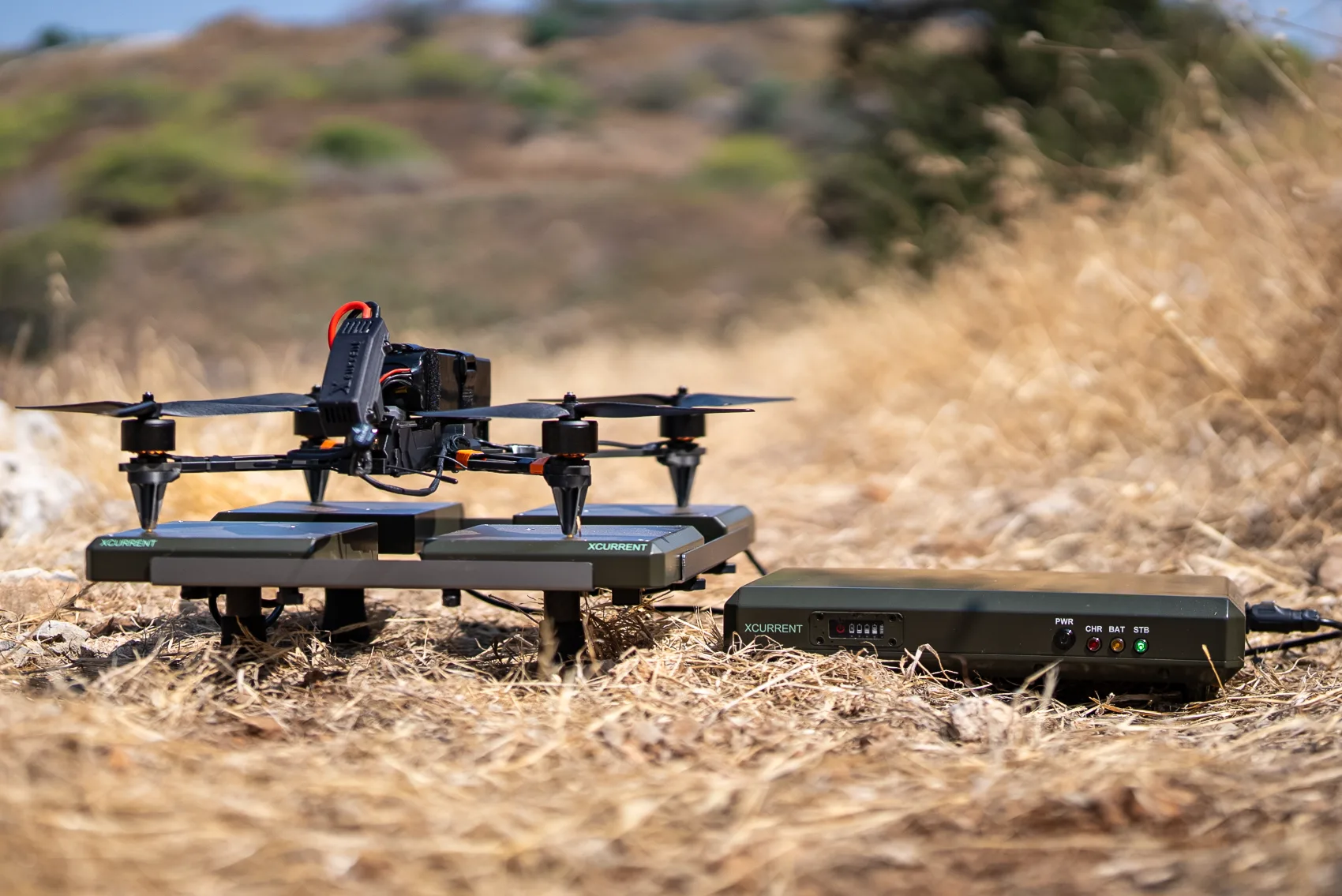 XCURRENT XPAD platform and base unit deployed in the field with an unmanned aerial system on station